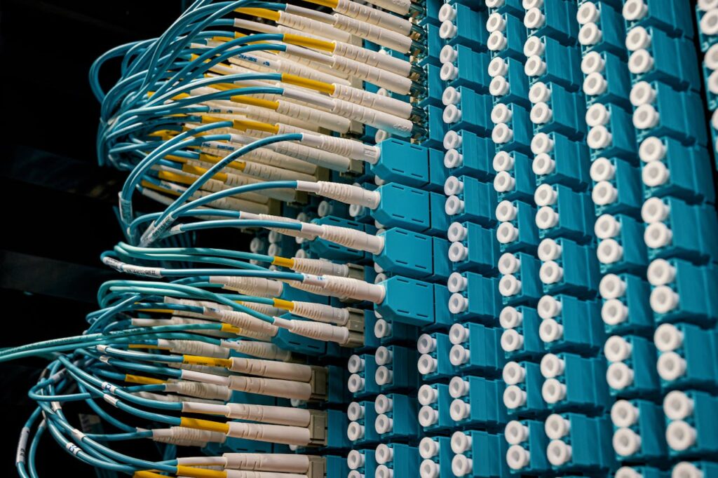 pexels photo 4486718 Detailed view of fiber optic patch cables connecting to a blue patch panel in a data center.